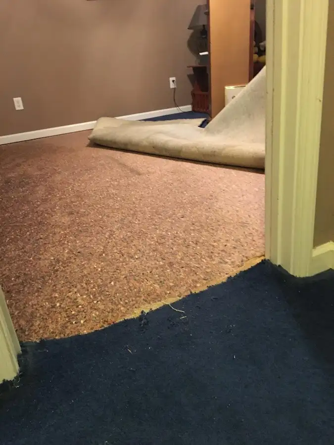 Carpet pad removal revealing water damage during Water Mitigation Services in Lilburn